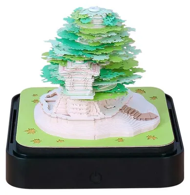 A 3D paper craft calendar with a green tree design sits on a black base with an LED light.
