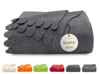 A folded gray fleece blanket with a decorative scalloped edge and a circular tag attached.