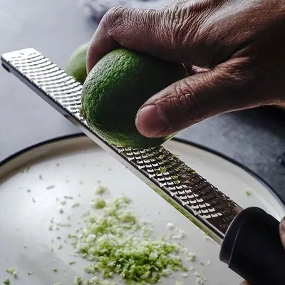 Immagine prodotto di Grattugia multifunzione in acciaio inossidabile Unyqoos® – grattugia affilata con manico ergonomico antiscivolo, compatta, ideale per parmigiano, agrumi, noce moscata e zenzero