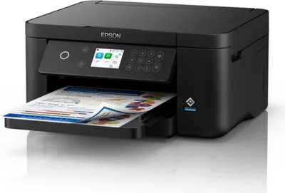 A black Epson Expression XP-5200 inkjet printer is shown from a front-side angle, with a sheet of paper partially printed with colorful graphics and text emerging from the output tray.
