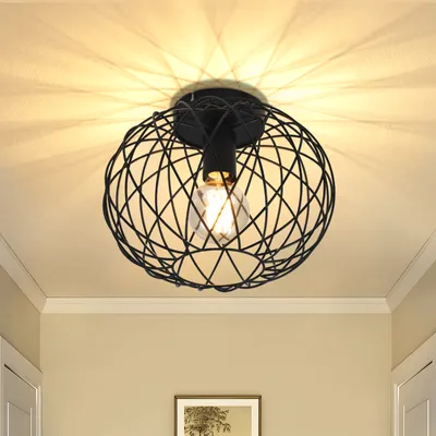 A black, cage-like ceiling light fixture with a visible light bulb, mounted on a white ceiling.