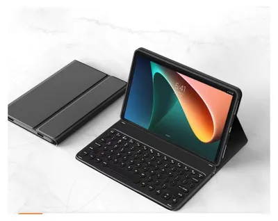 A black tablet with a keyboard case attached, shown on a marble-like surface.