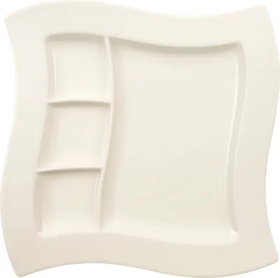 A white ceramic plate with multiple compartments.