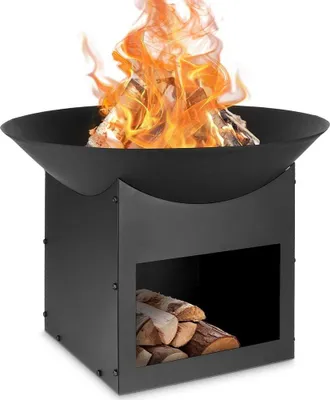 A black metal fire pit with a fire burning inside and firewood stored in the base.