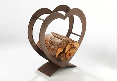 A heart-shaped metal log holder filled with firewood, set against a white background.