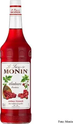 A bottle of Monin Raspberry syrup is shown against a white background.