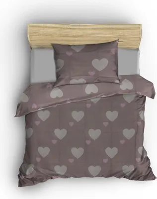 A top-down view of a bed with a duvet cover and pillow featuring a heart pattern.