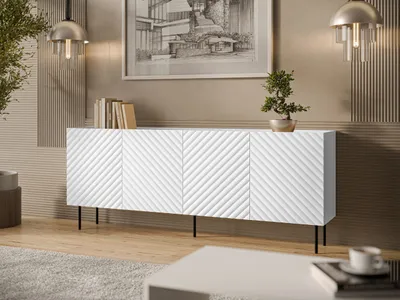 A white sideboard with a textured front and black legs is placed in a living room setting.