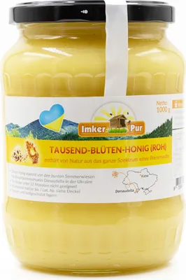A jar of honey with a label showing a landscape and product information.