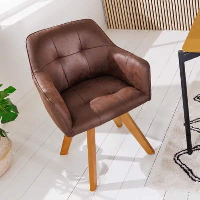 A brown armchair with wooden legs is shown in a room with a white floor and a wooden slatted wall in the background.
