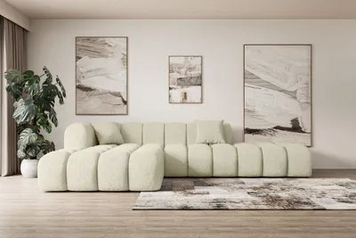 A modern living room with a beige sectional sofa, abstract art on the wall, and a large potted plant.