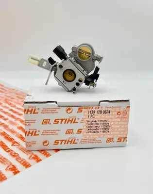 A Stihl carburetor is placed on top of its packaging box.