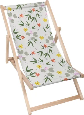 A close-up of a foldable wooden deck chair with a floral pattern.