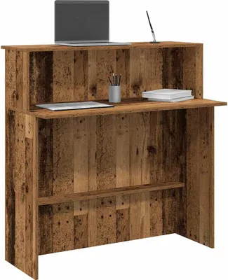 A reception desk with a rustic wood finish, a laptop, and some office supplies on top.