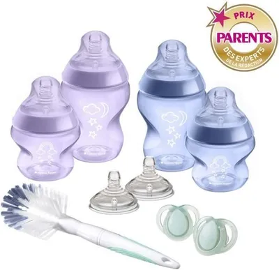 A collection of baby bottles, pacifiers, and a bottle brush arranged on a white background.