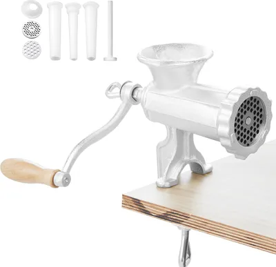 A manual meat grinder with accessories is clamped to a wooden table.