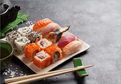 Produktbild von Wallario Fototapete Vliestapete, seidenmatte Oberfläche, einfache Verarbeitung, Größe 300 x 210 cm, Motiv Sushi-Menü mit grünem Tee