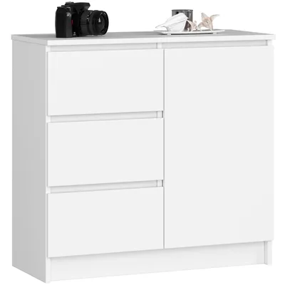 A white dresser with three drawers and a single door, shown against a white background. A camera and some decorative items are placed on top.