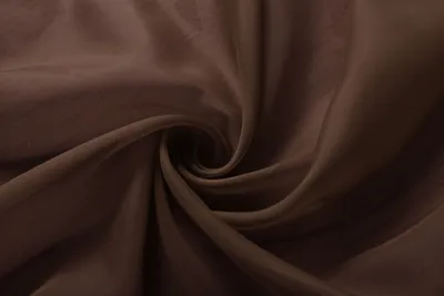 A close-up, swirled view of brown transparent fabric.