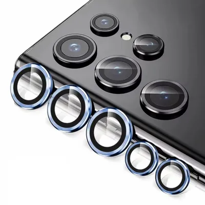 A close-up view of several camera lens protectors for a smartphone, arranged in a diagonal line on a white background.