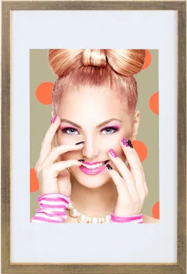 A woman with a bow in her hair and bright makeup is posing with her hands near her face, with orange polka dots in the background.