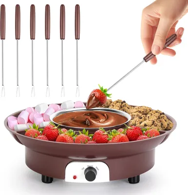 A hand is dipping a strawberry into a chocolate fondue pot.