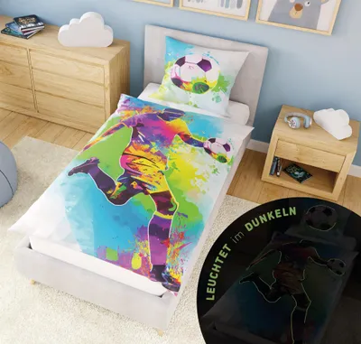 A child's bedroom with a bed made up with football-themed bedding.
