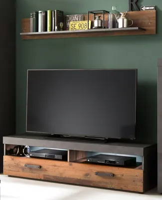 A modern TV stand with a television and shelf above it, decorated with various items.