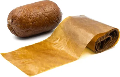 A roll of protein casing next to a sausage.