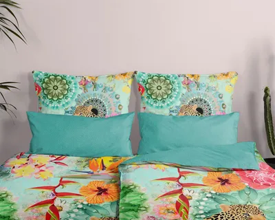 A close-up view of a bed with a colorful duvet cover and pillows.