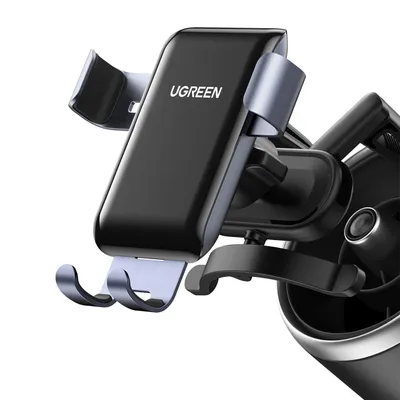 A close-up shot of a black and gray UGREEN gravity phone holder mounted on a car's air vent.