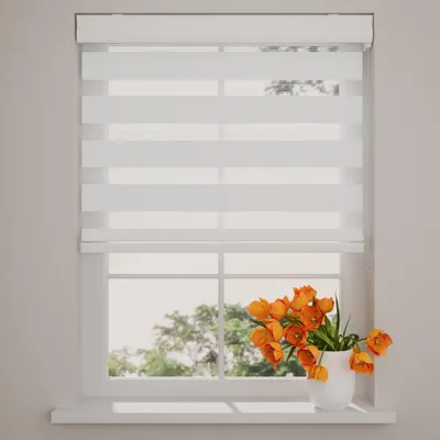 A white roller blind with horizontal stripes of opaque and sheer fabric is shown installed on a window. Orange tulips in a white vase sit on the windowsill.