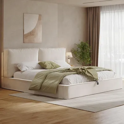 A bedroom scene with a bed, bedding, and a plant.