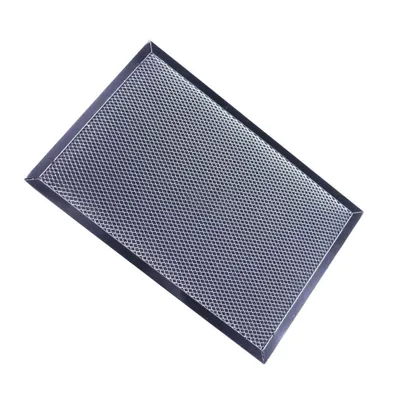 A rectangular metal filter with a honeycomb pattern, angled on a white background.