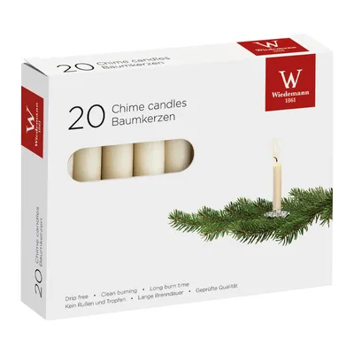 A box of chime candles with a sprig of evergreen.