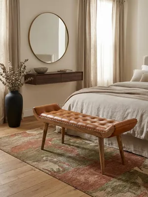Die Chesterfield Polsterbank aus der Vogelperspektive in einem wohnlichen Ambiente. Man erkennt die Proportionen der 125x38 cm großen Sitzfläche aus Leder und Mangoholz._#sku_SAFWL6.479#