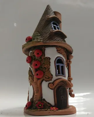 Ein kleines, turmartiges Haus mit einem kegelförmigen Dach. Design ist verspielt und fantasievoll.