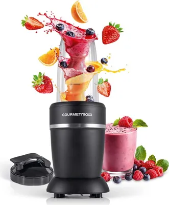 A black GOURMETmaxx nutrition mixer is shown with fruit and smoothie splashes around it, and a glass of smoothie to the side.