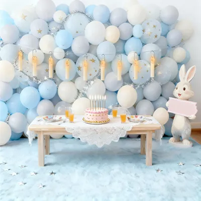 A birthday party setup with balloons, a cake, and a rabbit figurine.