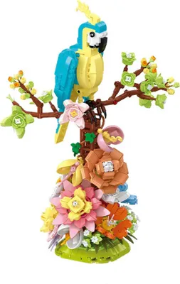 A model of a parrot perched on a branch with flowers at the base.
