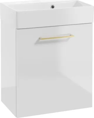 A white bathroom vanity with a sink and a gold handle.