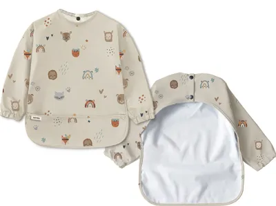 Two baby bibs with long sleeves are shown against a white background. One bib is laid flat, showing the front with a print of various baby animals and rainbows. The other bib is folded, revealing the back with snap closures and the waterproof lining.