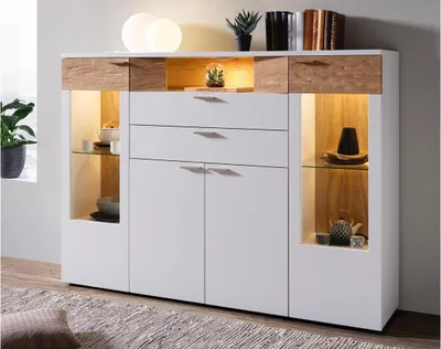A modern white and wood-tone highboard with integrated lighting, showcasing decorative items.