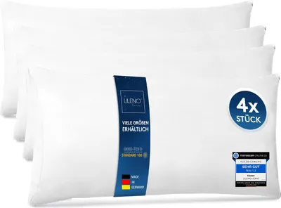 A stack of four white pillows, with a blue label on the front pillow.