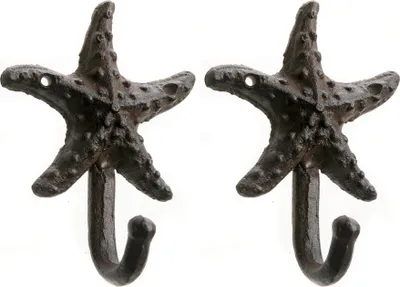 Two cast iron starfish-shaped hooks against a white background.