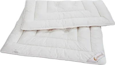 A white duvet folded on top of another white duvet, both with quilted patterns.