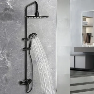 A black shower system with a rain shower head and a handheld shower head, mounted on a gray tiled wall. Water is flowing from both shower heads.