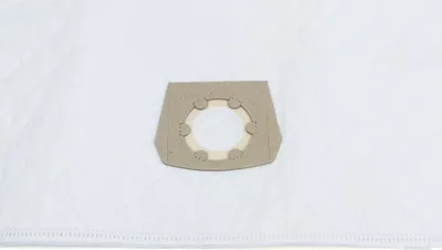 A close-up of a white vacuum cleaner bag with a beige cardboard connector.