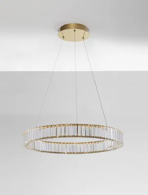 A modern chandelier with a circular design, suspended from the ceiling by thin wires.