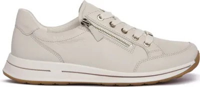 A side view of a cream-colored leather sneaker with a zipper.